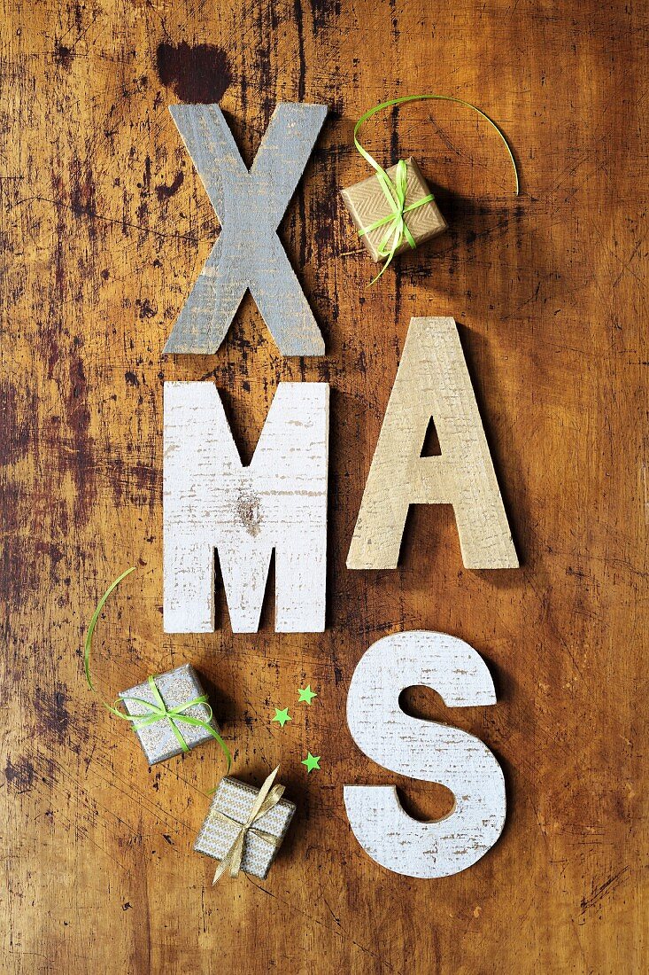 X-MAS: Deko-Buchstaben auf rustikalem Holz und kleine Geschenke