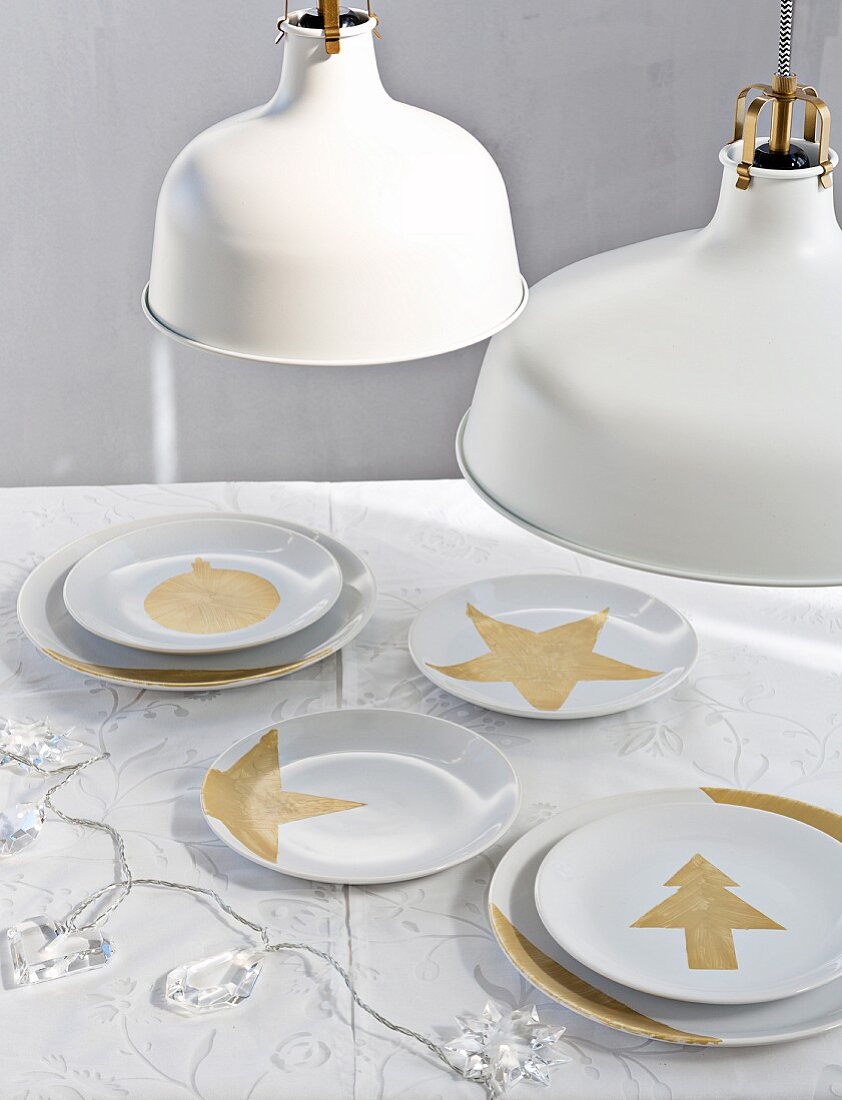Festive motifs hand-painted in gold paint on simple white plates