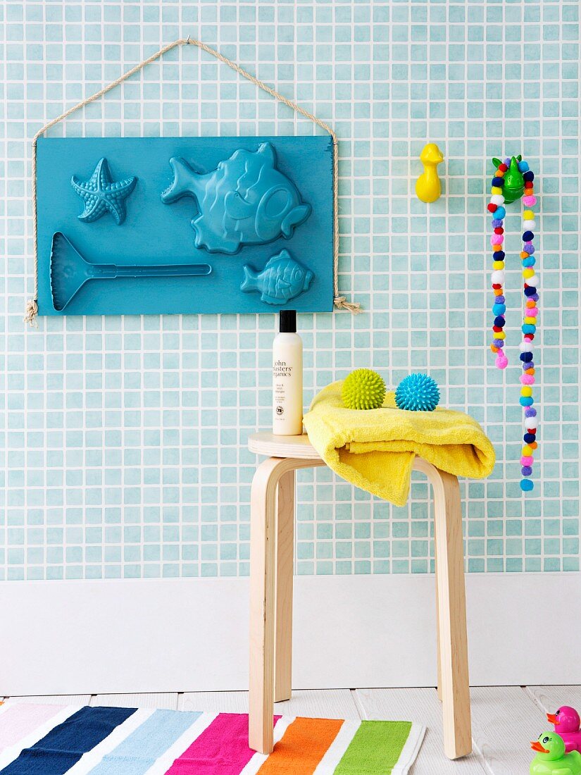 Hand-crafted arrangement of sand-pit moulds decorating bathroom wall