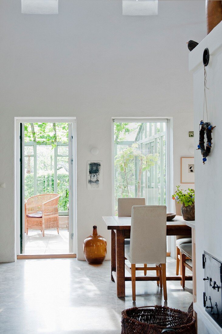 Bright dining area and open French windows leading to conservatory
