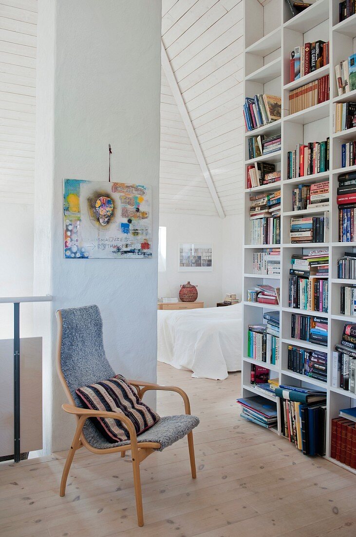 Retro armchair next to floor-to-ceiling bookcase