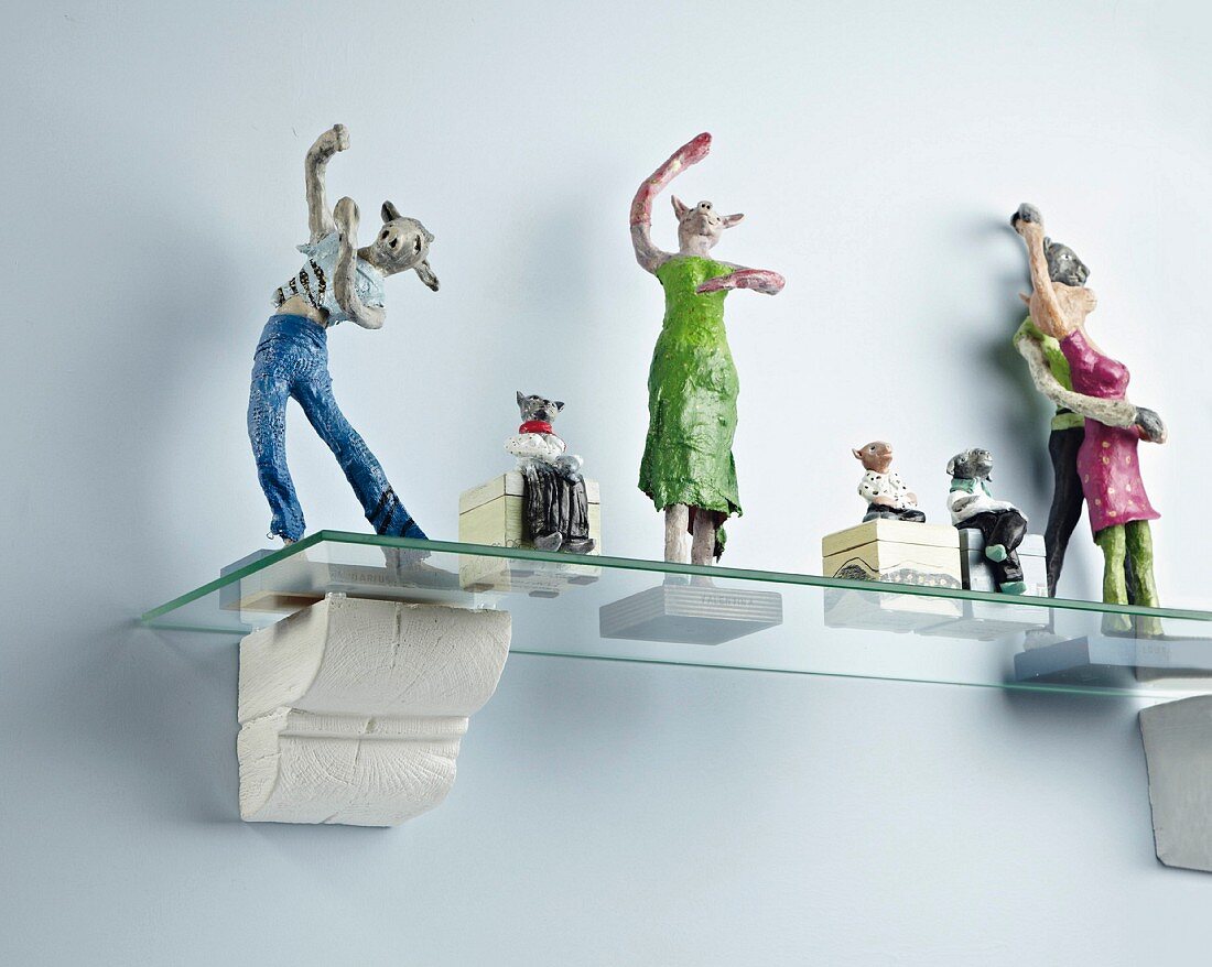 Various figurines on hand-made glass bracket shelf