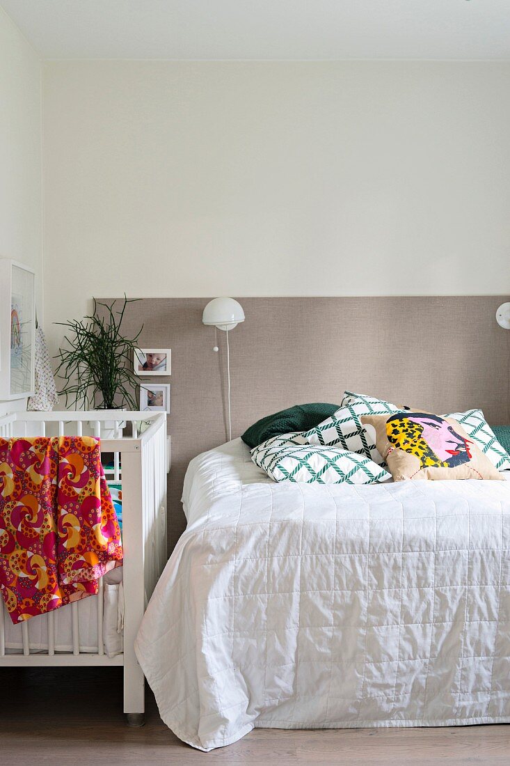 Schlafzimmer mit zweifarbiger Wand und Babybett