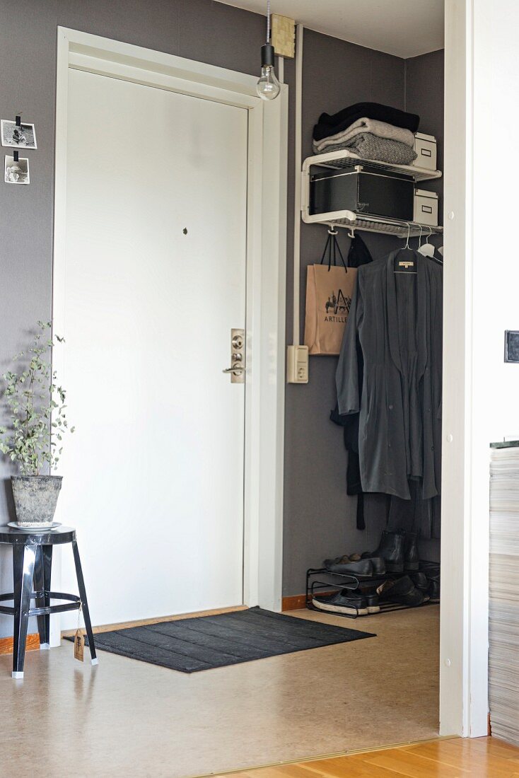 Hallway with grey-painted walls, white front door and minimalist cloakroom area