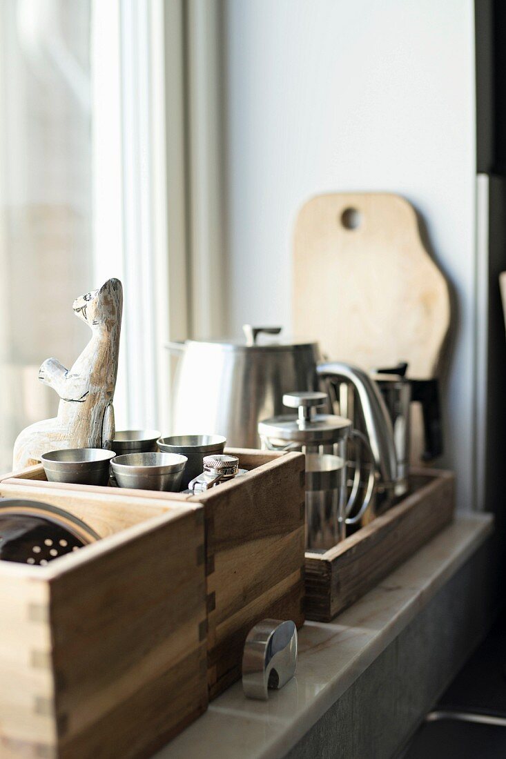 Wooden crates of kitchen utensils on windowsill