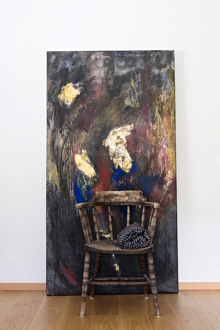 Vintage wooden armchair in front of modern painting