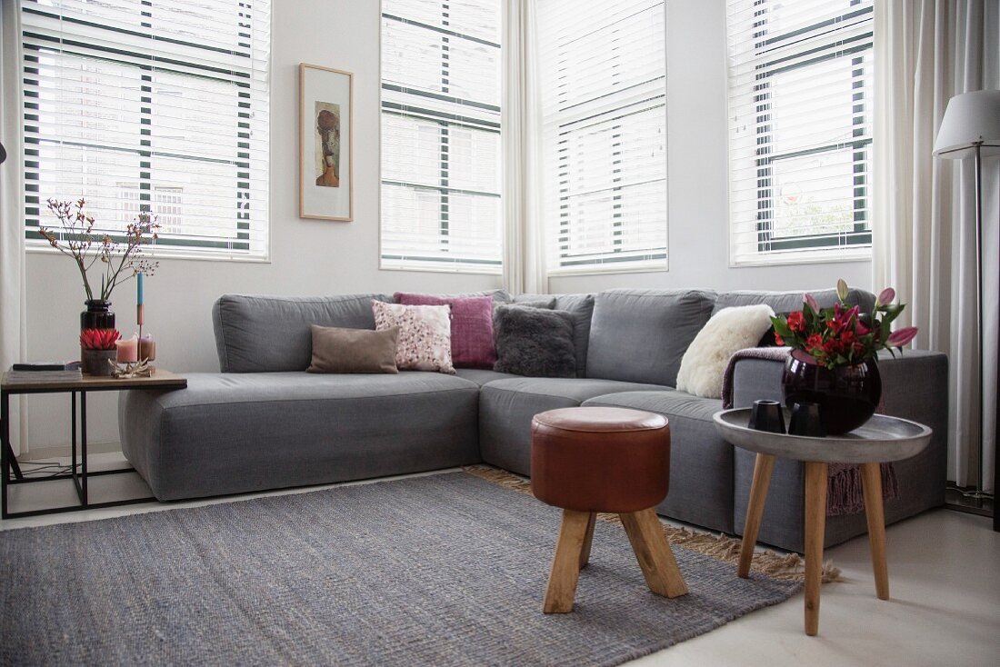 Skandinavisches Wohnzimmer mit grauem Sofa und Beistelltischen
