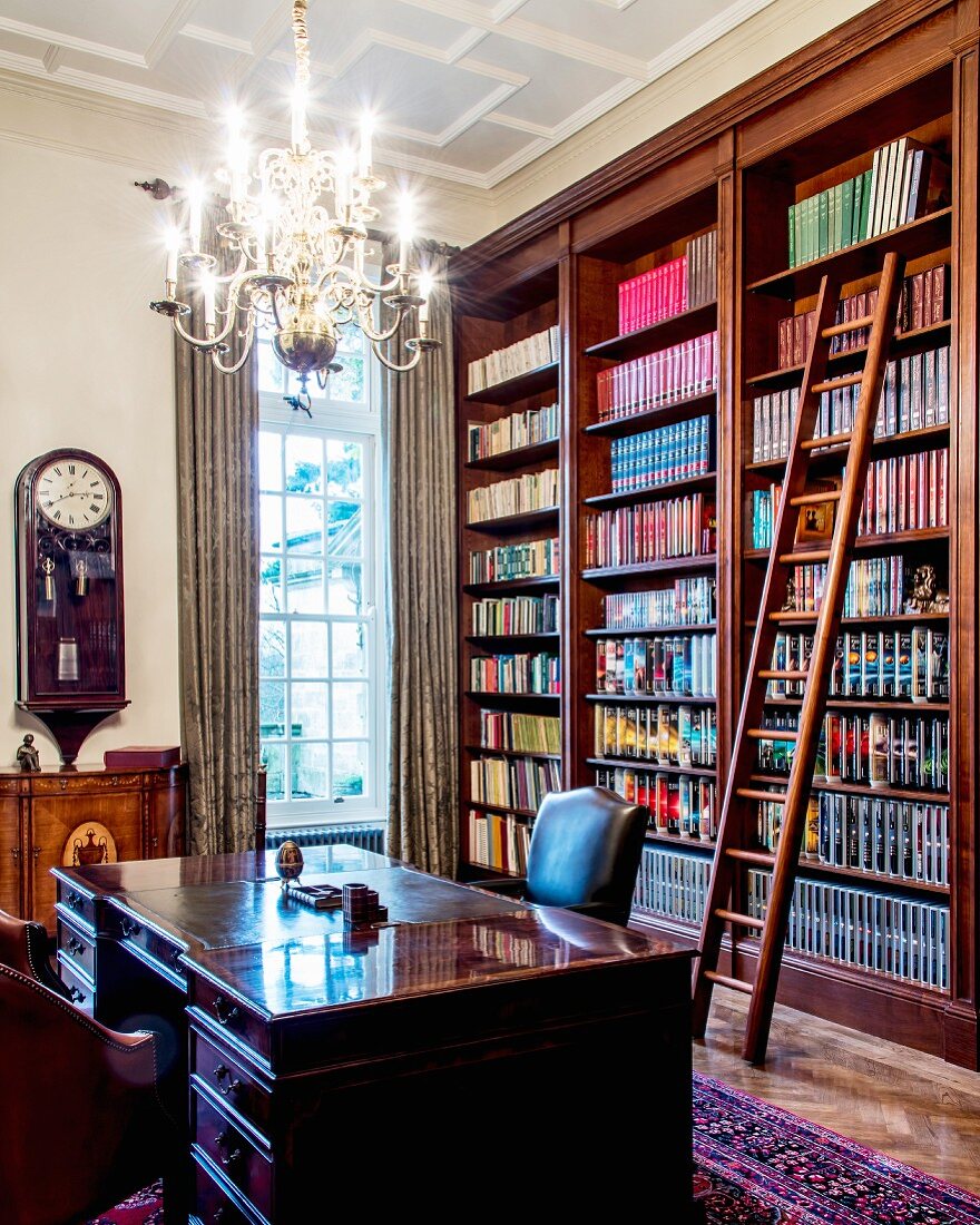 Traditional bookcase with library ladder behind heavy desk