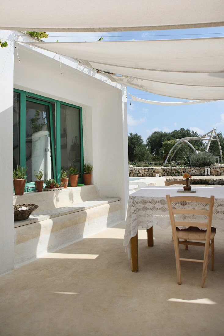 Mediterraner Hof mit Sonnensegel und Tisch