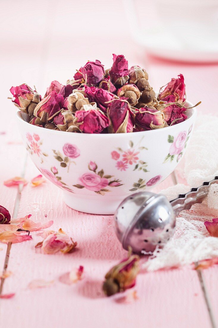 Getrocknete Rosenblüten aus Marokko in einer Schale, Teesieb, Zutaten für Rosentee