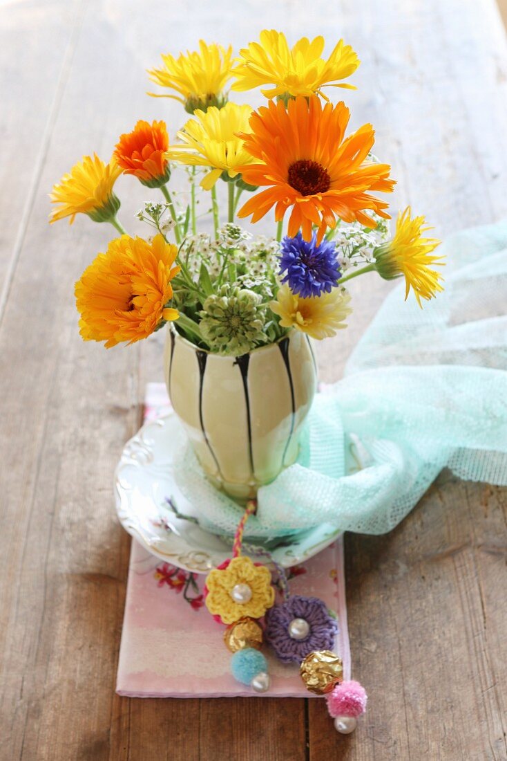 Vase of summer flowers decorated with crocheted flowers