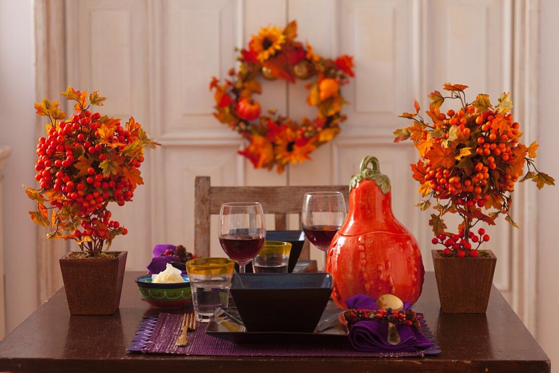 Table set for two autumnally decorated with pumpkin and berries