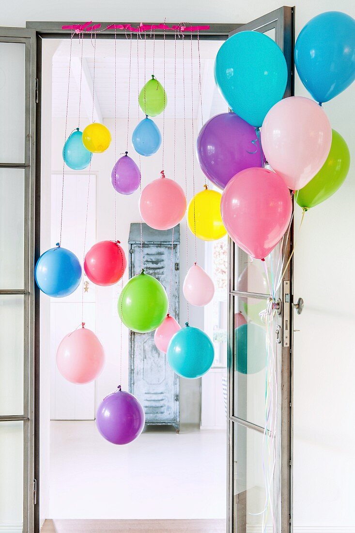 Bunte Luftballons an Türrahmen und Tür