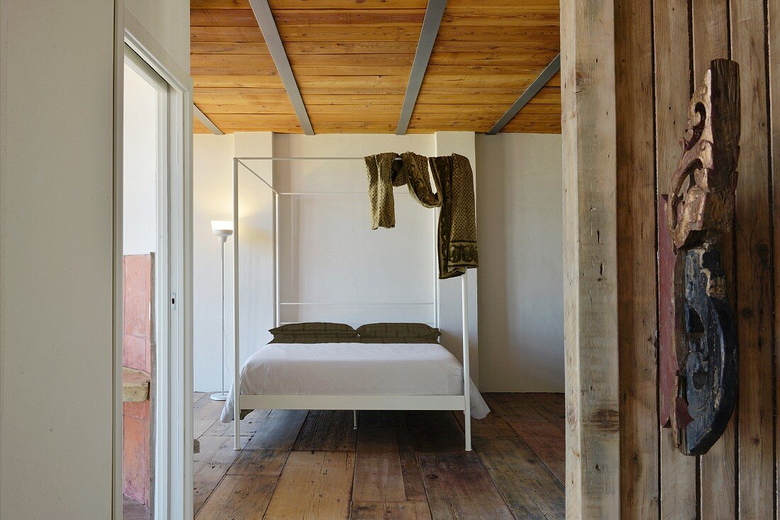 Modernes Himmelbett im Schlafzimmer mit altem Holzboden