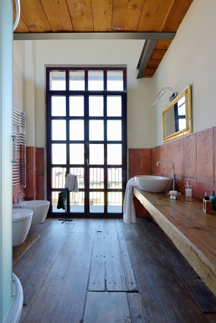 Rustikales Badezimmer mit altem Holzboden und Sprossenfenster