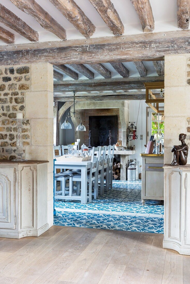 View from dining room into country-house kitchen with blue and white ornamental floor tiles