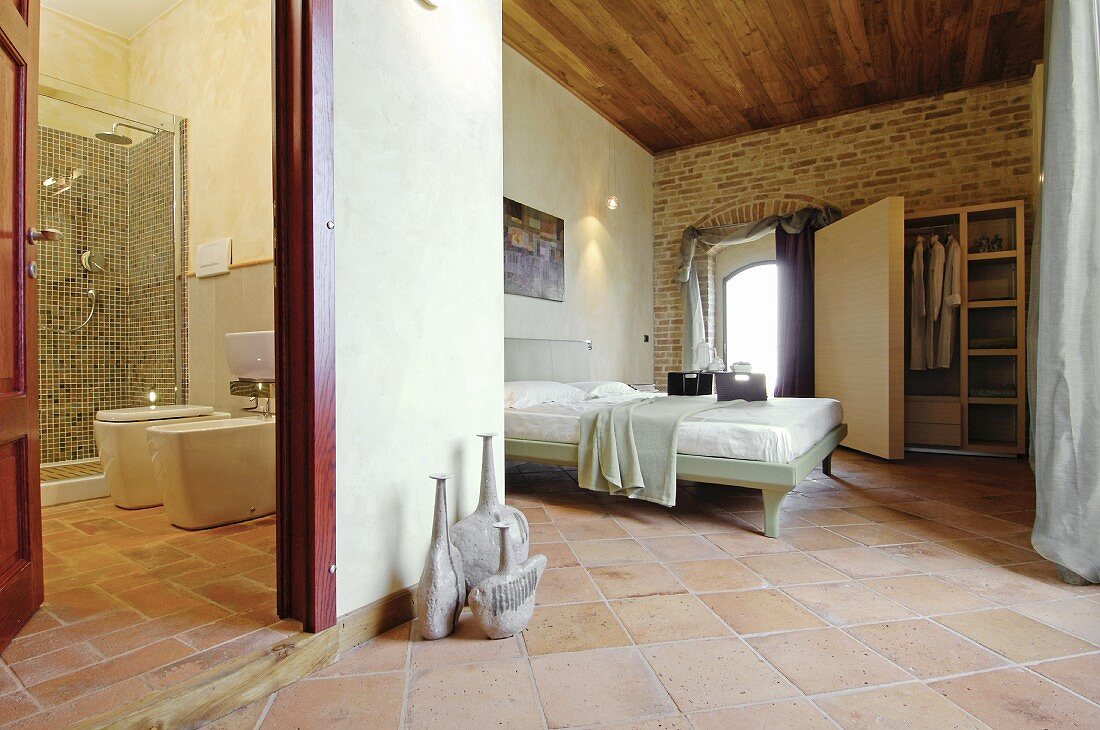 Blick in mediterrane Bad und Schlafzimmer mit Terracottafliesen