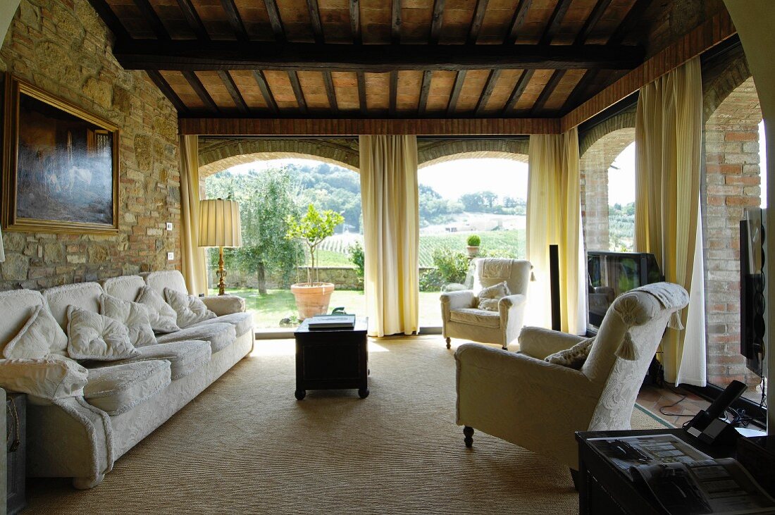 Mediterranes Wohnzimmer mit Steinwand und Panoramafenstern