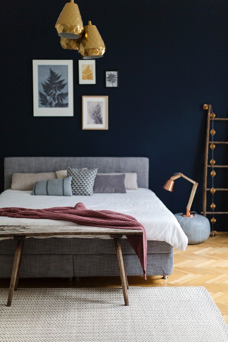 Schlafzimmer mit blauer Wand und goldener Lampe
