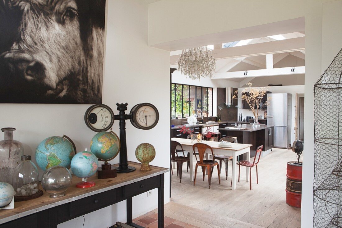 Blick über Globussammlung in offene Küche mit Essplatz