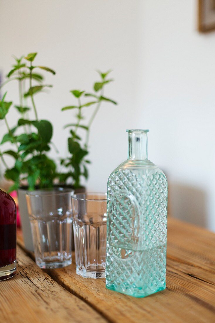 Glasflasche mit Relief als Wasserkrug auf dem Tisch