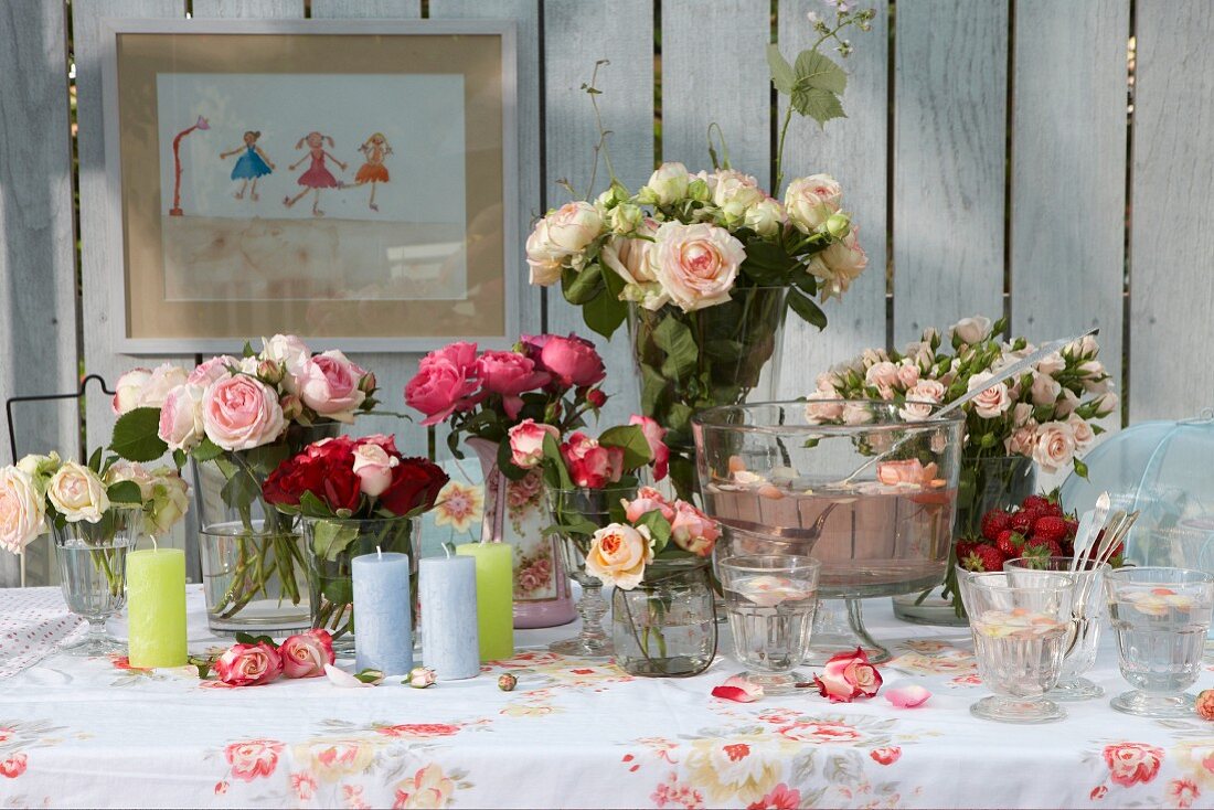 Summery buffet and various vases of roses on table