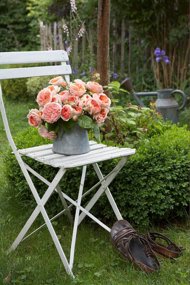 Bunch of roses in zinc pot on garden chair