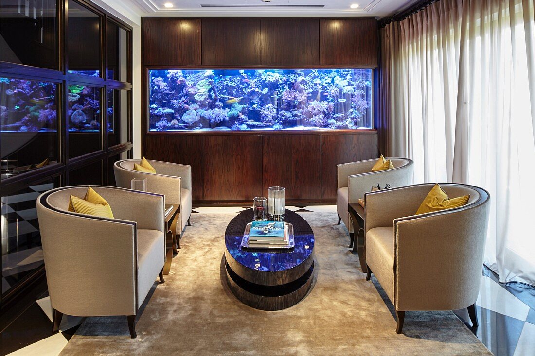 Klassische Lounge mit vier Polstersesseln und einem großem Aquarium