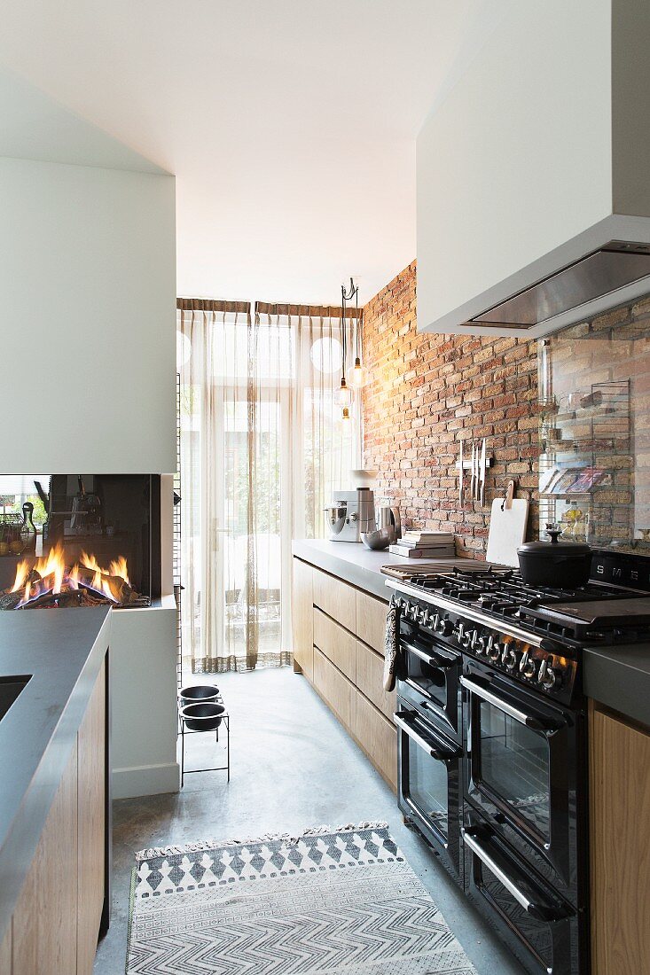 Vintage-style cooker and brick wall in modern kitchen