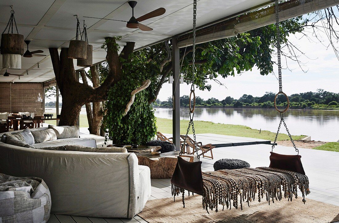 Sofa landscape and hanging lounger on covered terrace, river view