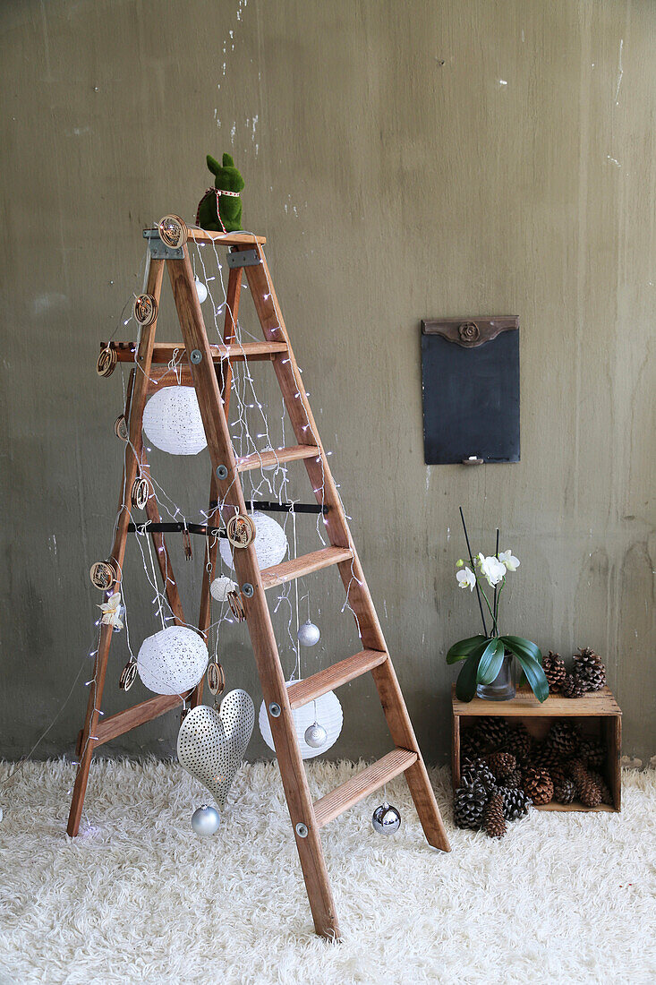 DIY Christmas fairy lights made from lanterns on a wooden stepladder