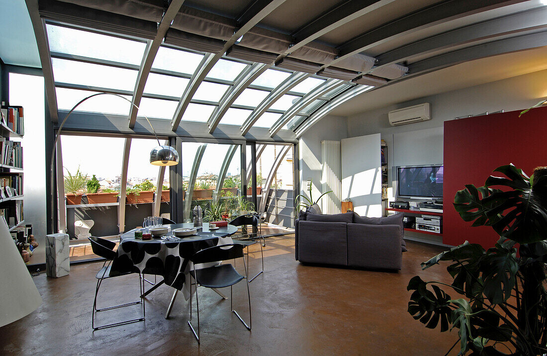 Essbereich und Lounge in offenem Wohnraum mit Metall- und Glaselementen