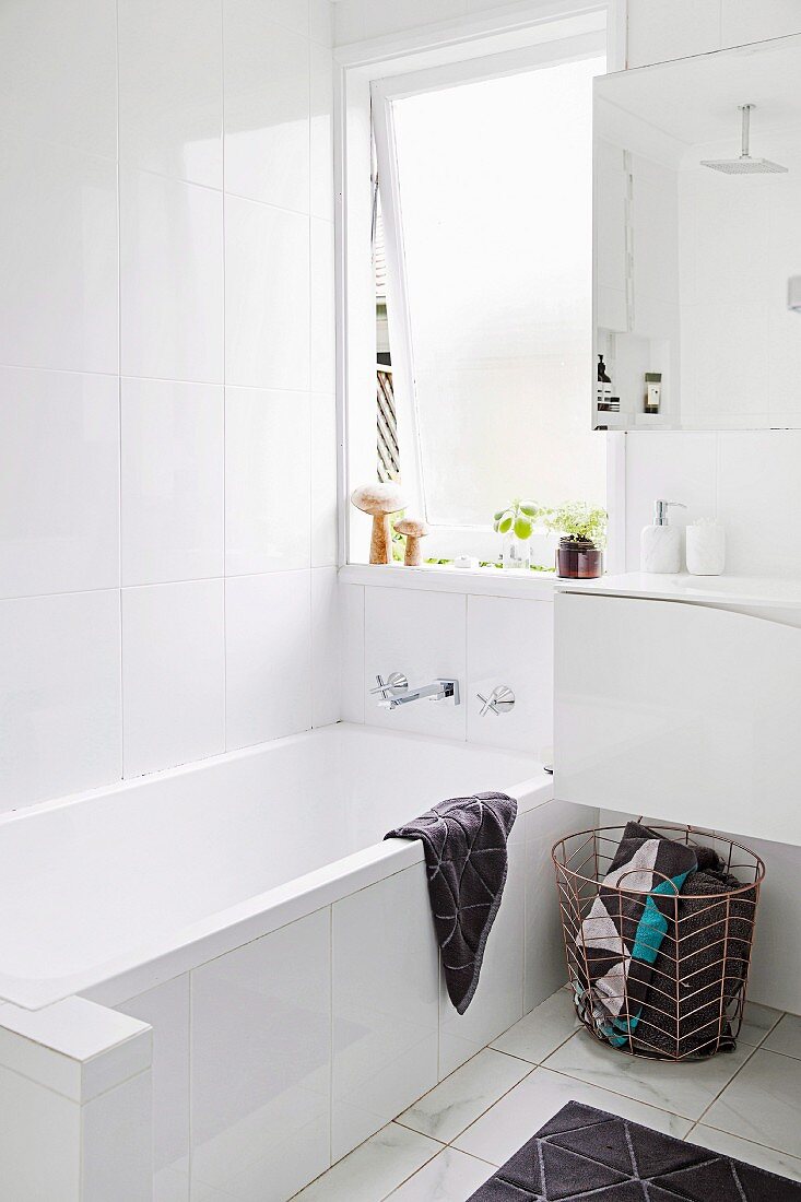 White bathroom with tub under the window