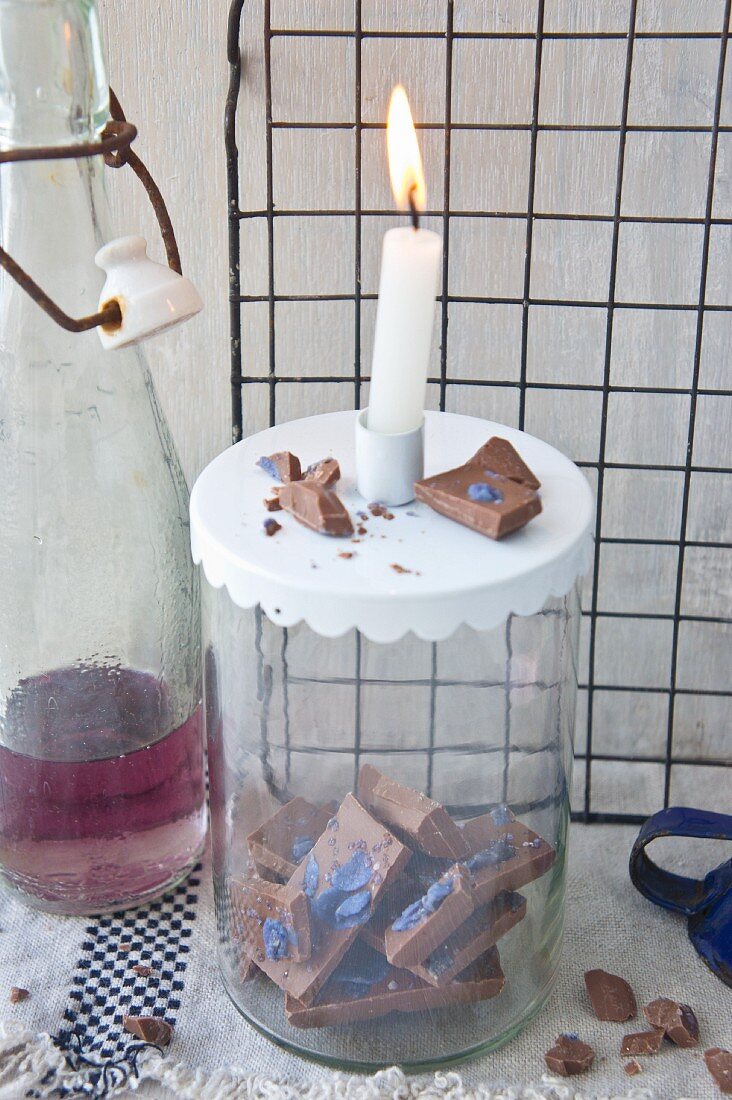 Veilchen-Schokolade im Vorratsglas mit Kerze und Veilchensirup