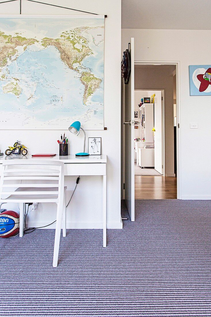 Youth room with striped carpeting, white desk and hung map