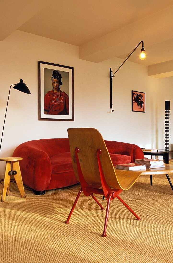 Wohnzimmer mit rotem Sofa und Wandleuchte