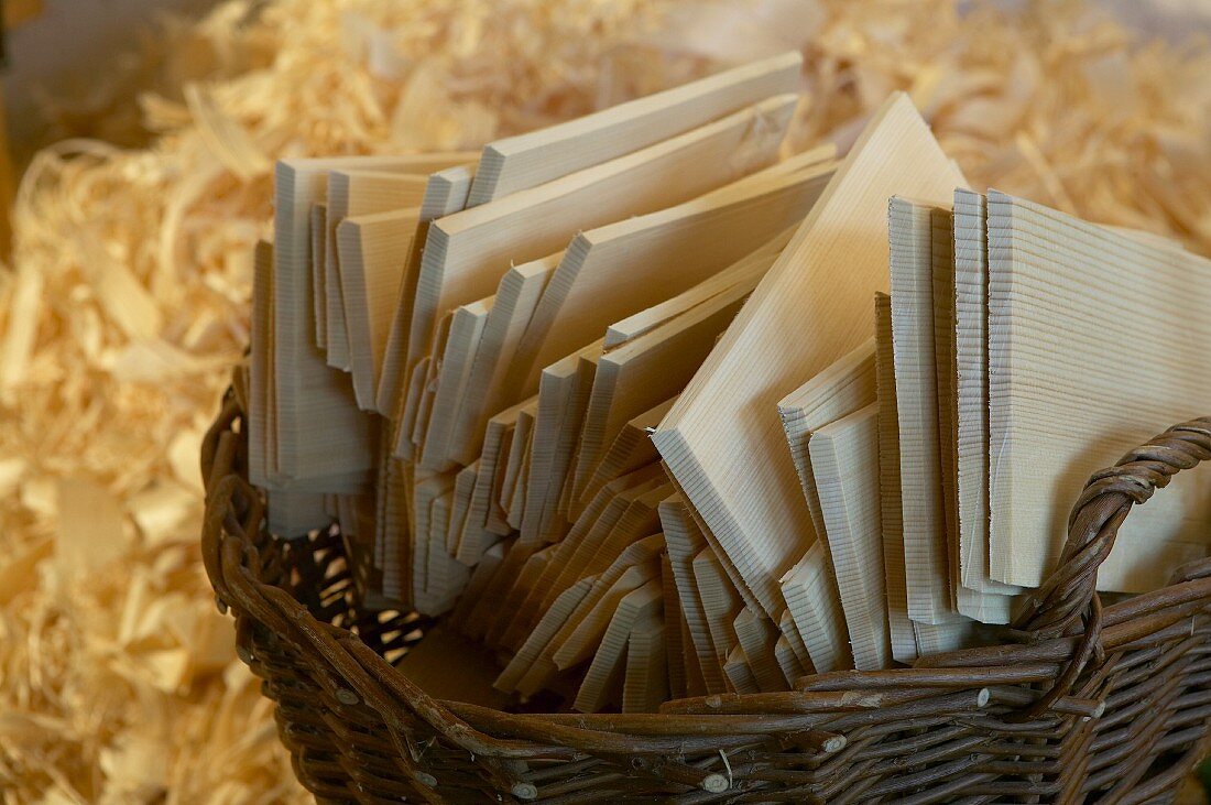 Wicker basket of wooden shingles against background of wood shavings