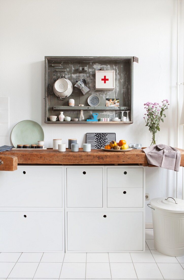 Alte Werkbank und weiße Schränke als Arbeitsfläche in der Küche
