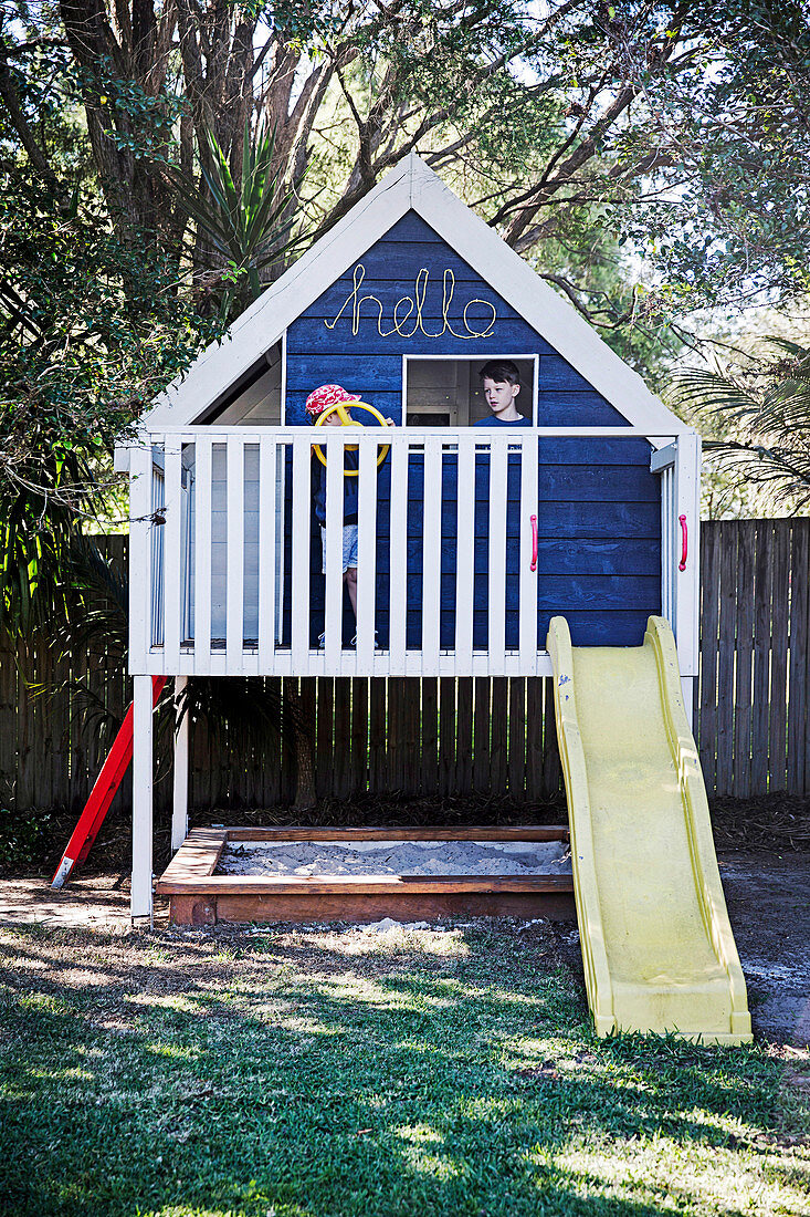 Elevated play house with slide and sandpit in the garden