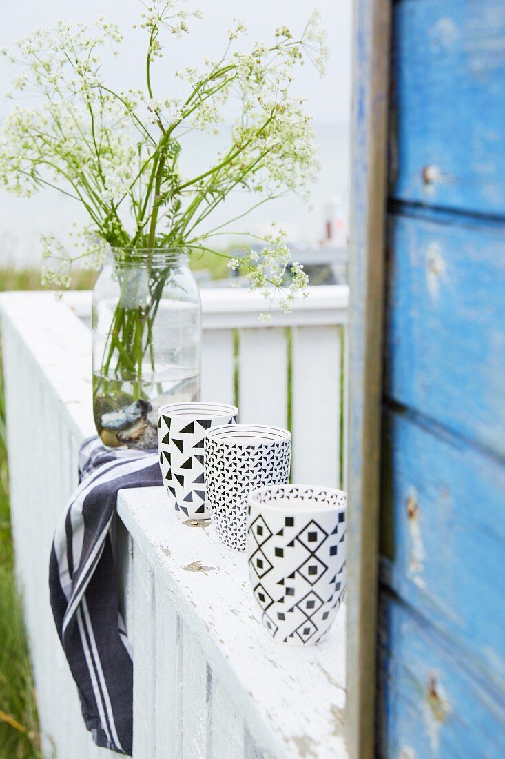 Mugs with black and white graphic patterns on balustrade
