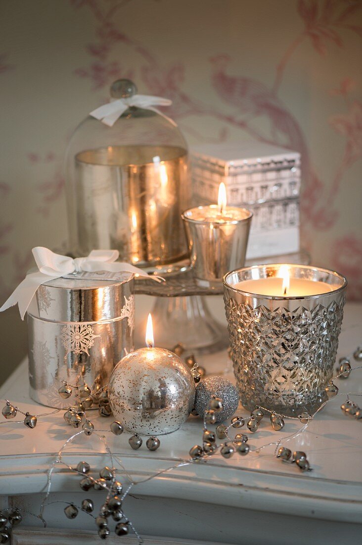 Silber funkelndes Arrangement aus Kerzen, Windlichtern und Dosen aus Bauernsilber