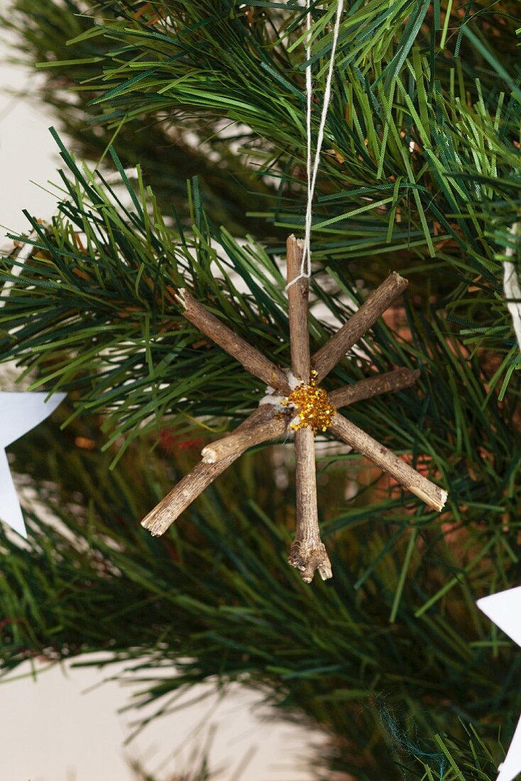 Ein gebastelter Stern aus Ästen hängt am Weihnachtsbaum