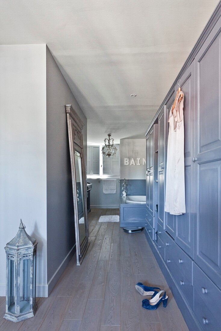 View along hallway with fitted cupboards into open-plan bathroom