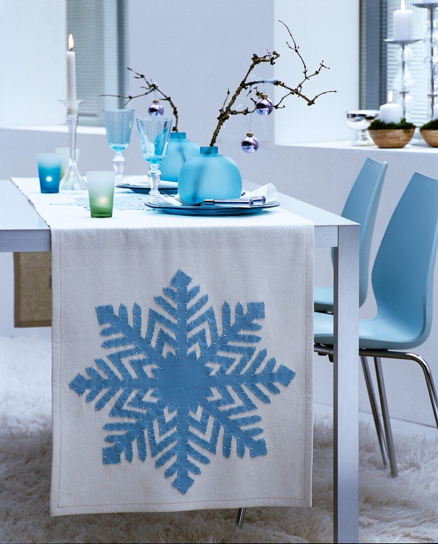 Weißer Tischläufer mit aufgenähtem, eisblauem Schneeflockenmotiv