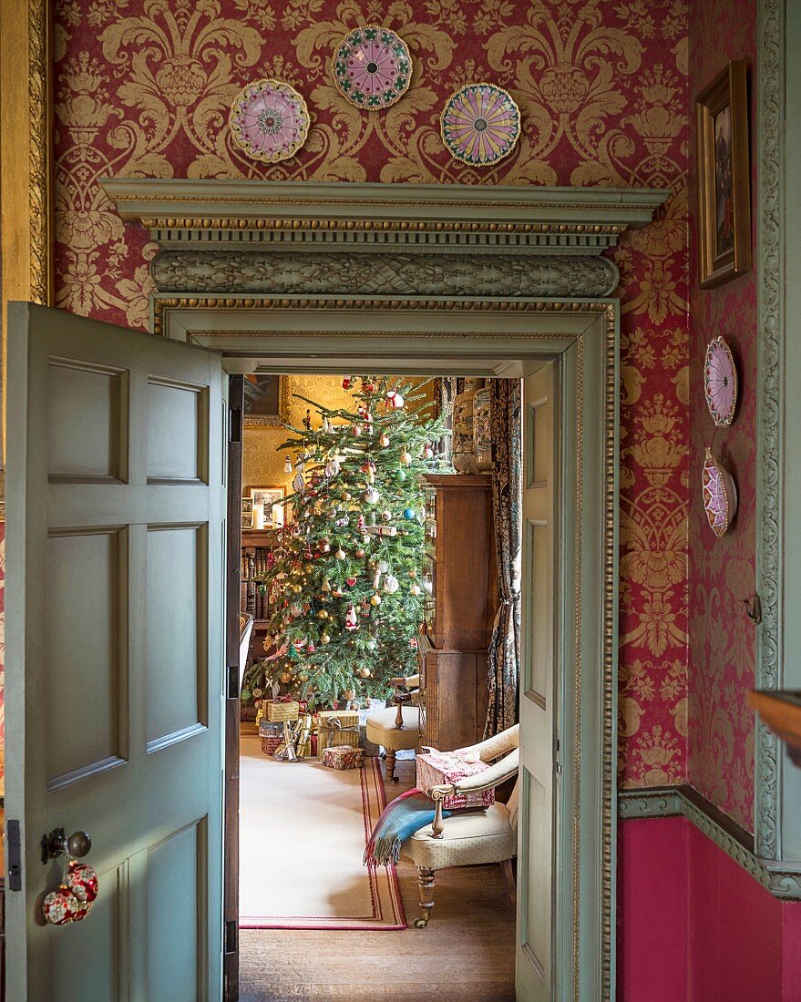 View into festive living room through antique door