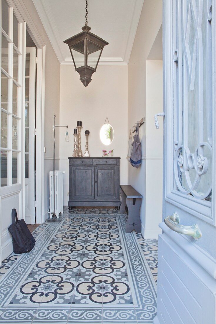 Hall in shades of grey with patterned tiles, lanterns and stucco ceiling