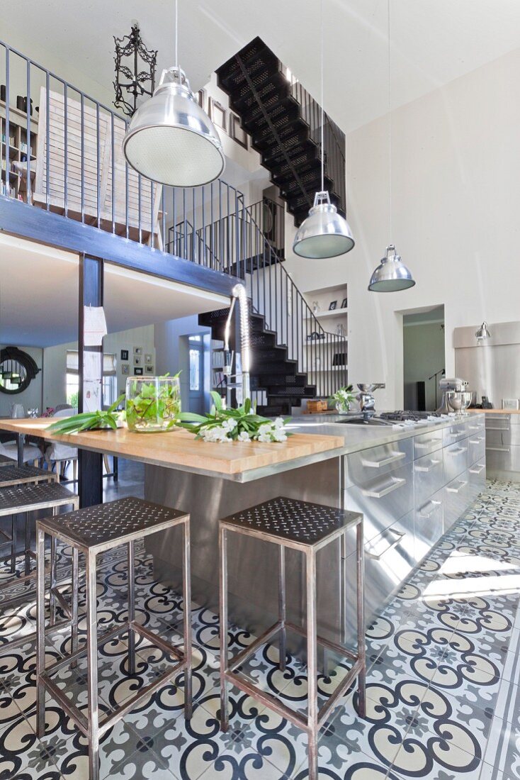 Modern stainless steel kitchen with patterned, cement floor tiles