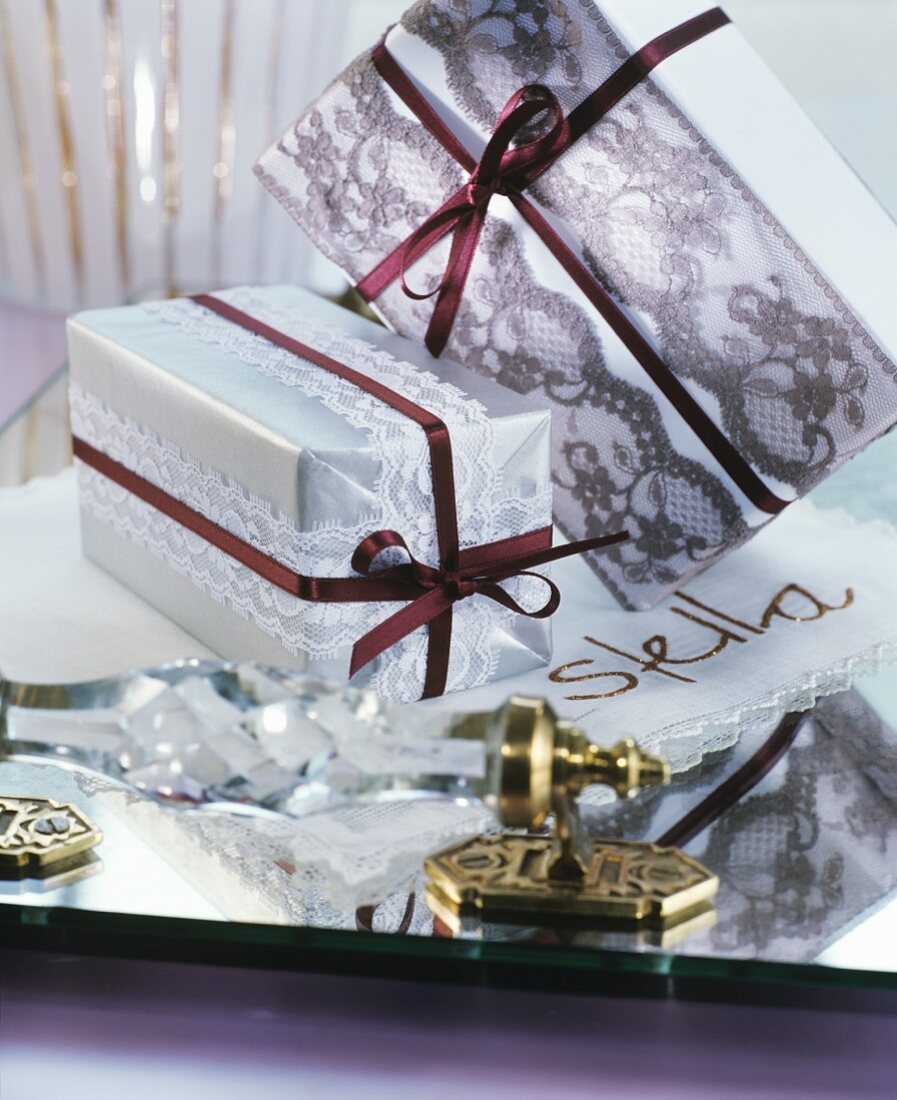 Presents wrapped with lace ribbons in mirrored tray