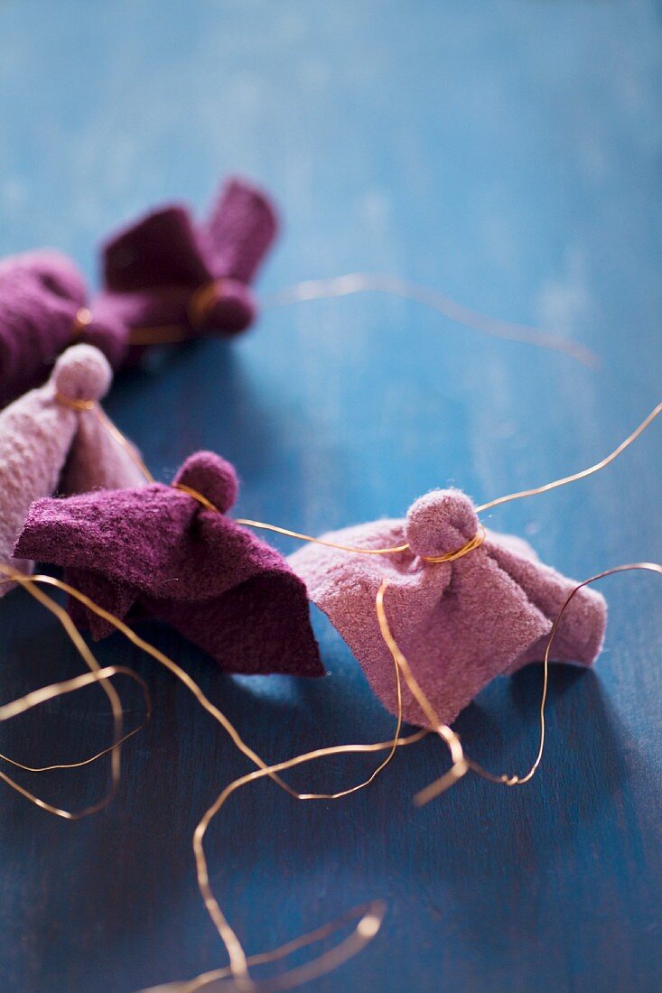 Pieces of felt in berry shades tied with copper wire