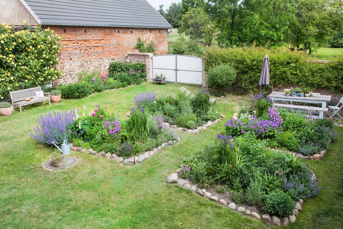 Beds edged with stones in summery cottage garden